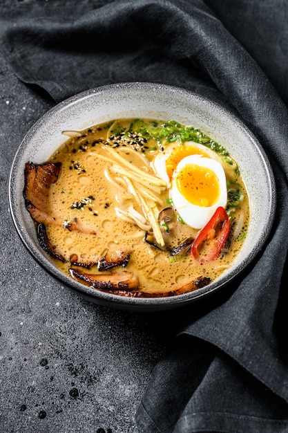 Ramen sopa de macarrão asiático com carne de língua de carne, cogumelos e ovo em conserva de ajitama. fundo preto. vista do topo