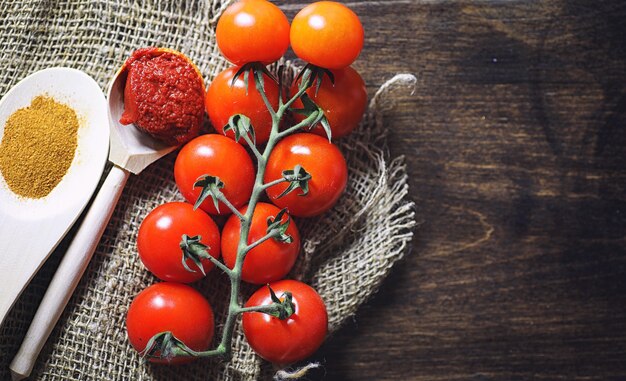 Ramifique com tomate cereja fresco. Tomates vermelhos maduros