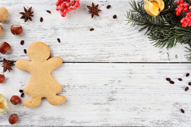 Ramita de pino de Navidad con especias y pan de jengibre sobre fondo de madera de color