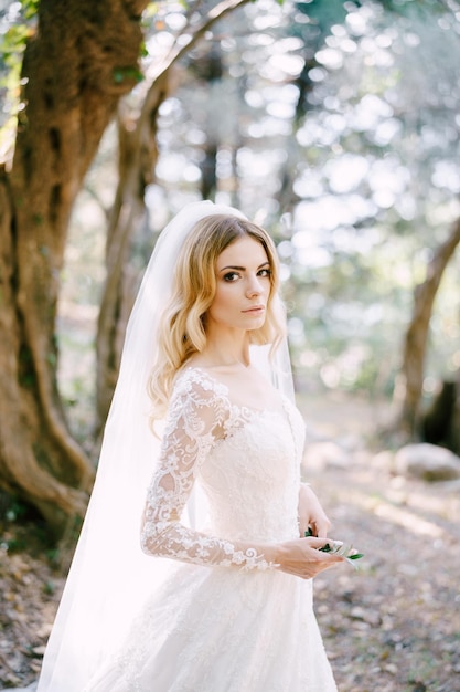 Ramita verde en manos de la novia con un vestido bordado blanco