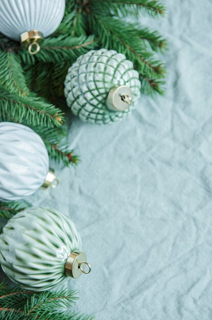Ramitas de abeto con adornos navideños en el fondo textil arrugado lino verde