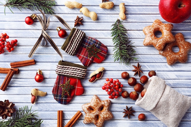 Ramitas de árbol de Navidad con galletas, manzana y especias sobre fondo de madera de color
