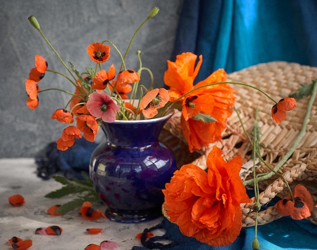 Ramo de amapolas rojas en florero de cerámica azul
