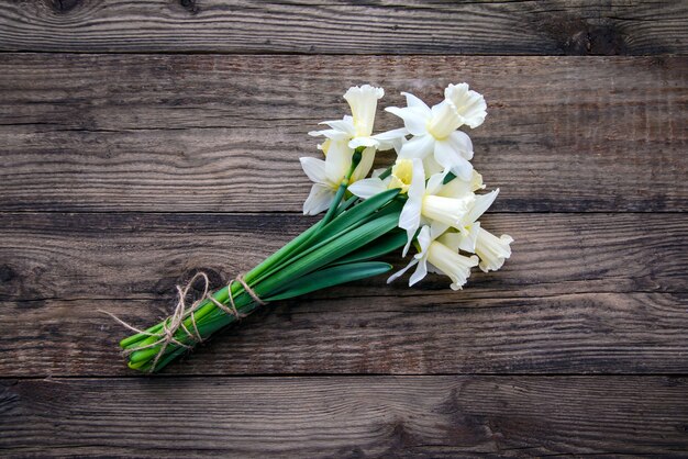 Ramo de blanco con narcisos amarillos sobre mesa de madera