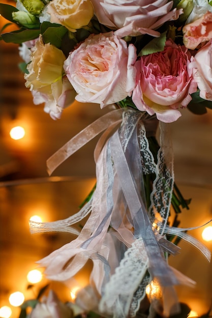 Ramo de boda delicado y muy hermoso de rosas eustoma verdor de pie sobre la mesa del espejo