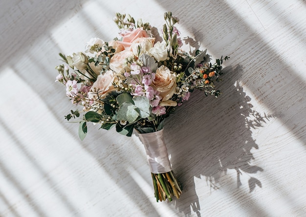 Ramo de boda de flores de peonías en el piso de los recién casados.