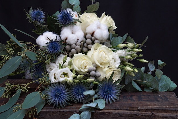 Ramo de boda de invierno de rosas blancas, algodón y eringium en negro. El ramo de la novia.