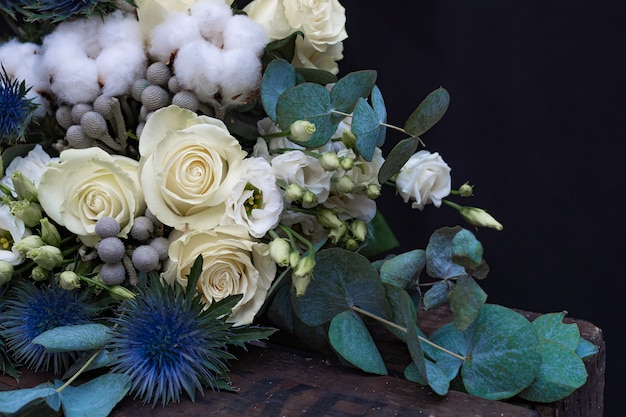 Ramo de boda de invierno de rosas blancas, algodón y eringium en negro. El ramo de la novia.