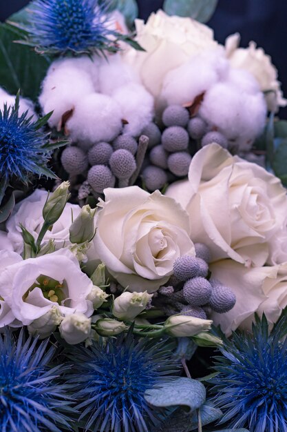 Ramo de boda de invierno de rosas blancas, algodón y eringium en negro. El ramo de la novia.