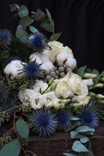 Ramo de boda de invierno de rosas blancas, algodón y eringium en negro. El ramo de la novia.