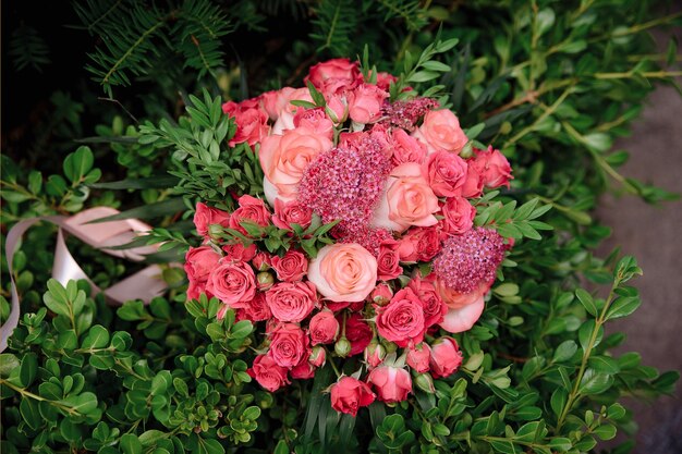 El ramo de la boda de la novia de rosas rojas y rosadas. Ramo de gran día.