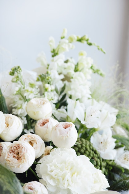 Un ramo de boda de rosas blancas y eucalipto sobre fondo gris vista lateral.Los preparativos de la mañana de la novia. Detalles de una elegante boda europea.