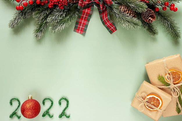 Ramo de abeto, 2022 e presentes em um fundo verde, vista superior. Conceito de Natal e ano novo. Lugar para texto