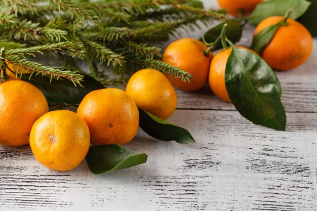 Ramo de abeto e tangerinas na mesa de madeira velha