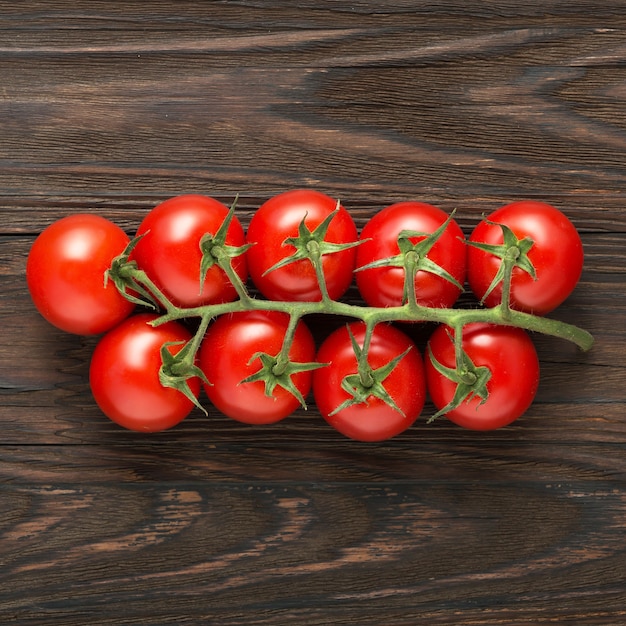 Ramo de tomate cereja em fundo de madeira