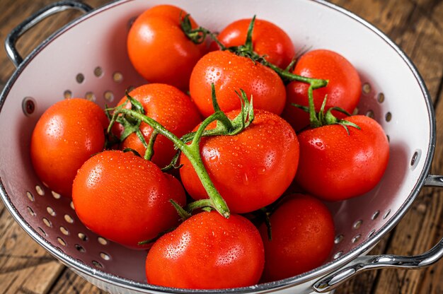 Ramo de tomate cereja vermelha na peneira