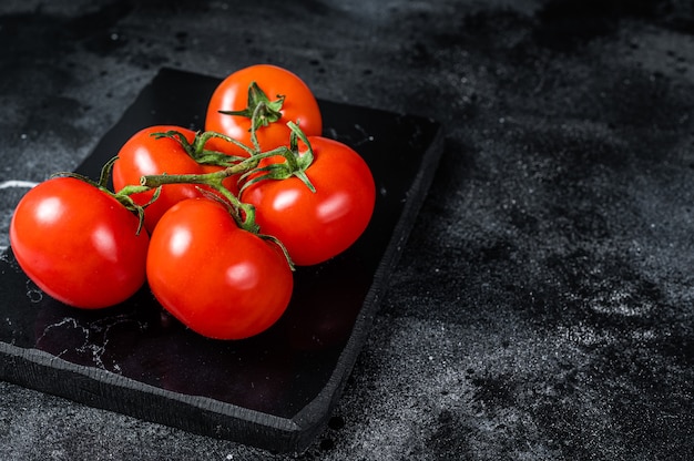 Ramo de tomate cereja vermelho no tabuleiro de mármore