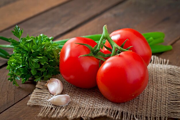 Ramo de tomate fresco em fundo de madeira