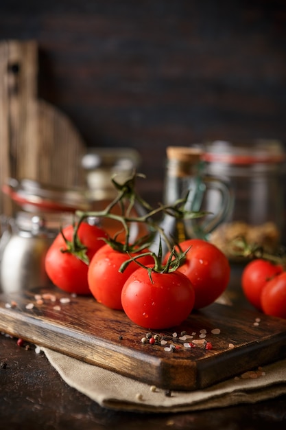 Ramo de tomate fresco maduro na tábua