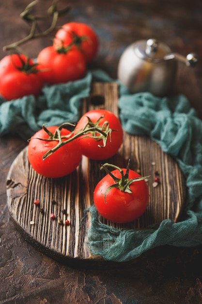 Ramo de tomate fresco maduro na tábua