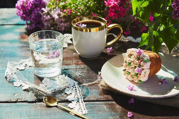 Ramo de verão com xícara de café, lindo cupcake, copo de flores aquáticas e decoração de renda