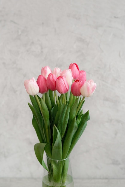 Un ramo de delicados tulipanes rosas en un jarrón para unas vacaciones. Día de la madre, cumpleaños, día de san valentín. tarjeta de felicitación. enfoque selectivo suave.