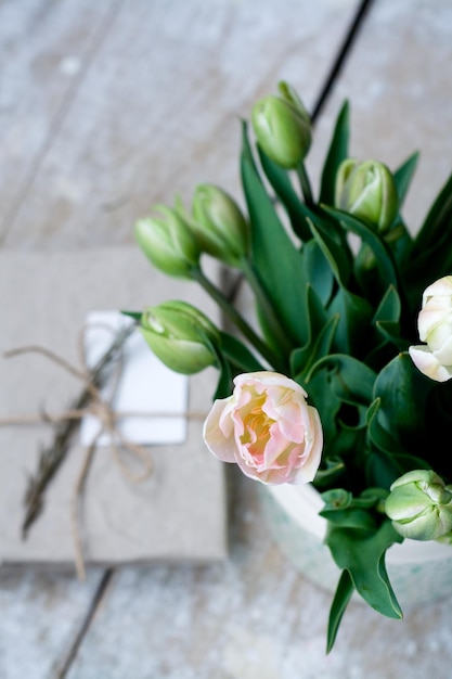 Ramo de delicados tulipanes rosas sobre un fondo de madera