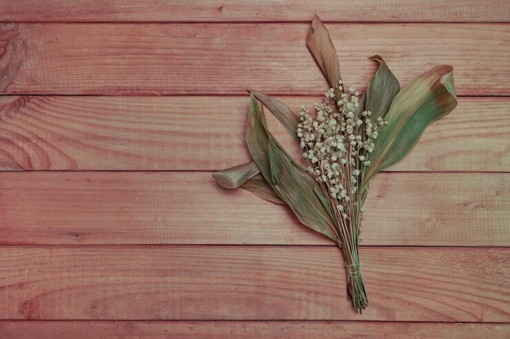 Foto ramo desvanecido convallaria majalis flores en una mesa de madera roja patrón de fondo para el diseño