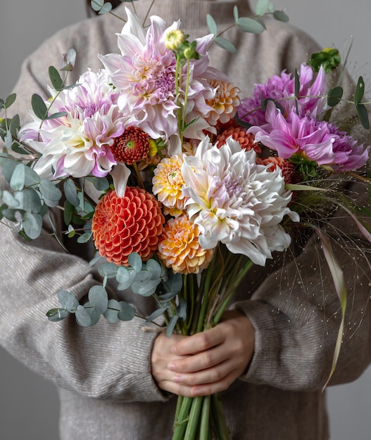 Ramo festivo brillante con flores de crisantemo en manos femeninas, el concepto de la fiesta del día de la mujer.