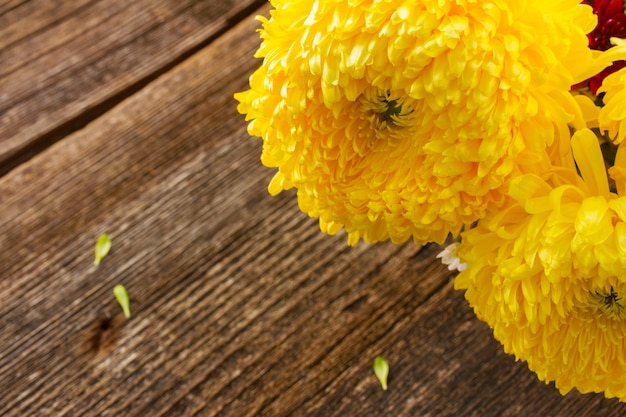 Ramo de flores amarillas de mamá de cerca en la mesa de madera