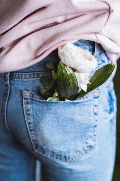 Ramo de flores blancas en el bolsillo trasero de los jeans de mujer Minimalis