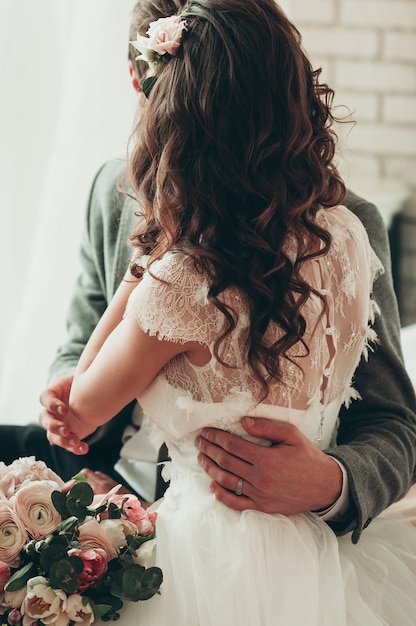 ramo de flores de la boda, una pareja sentada en la cama, vista posterior