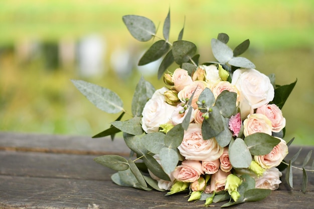 Ramo de flores de boda tirado en un banco sobre un fondo borroso