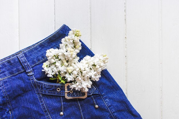 Foto ramo de flores en bolsillo vaquero azul. espacio para texto