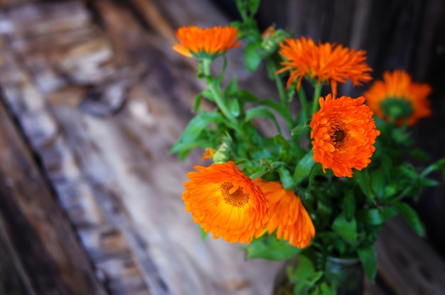 Ramo de flores de caléndula en madera vintage