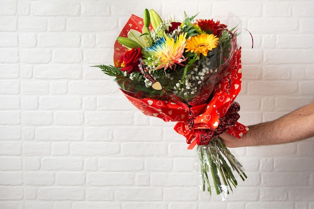 Ramo de flores diferentes en la mano de un hombre