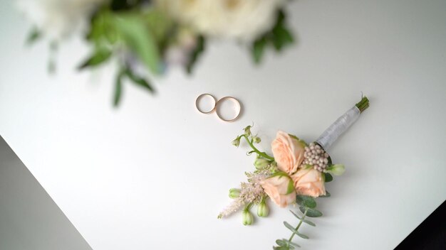 Foto un ramo de flores y dos anillos de bodas de oro.
