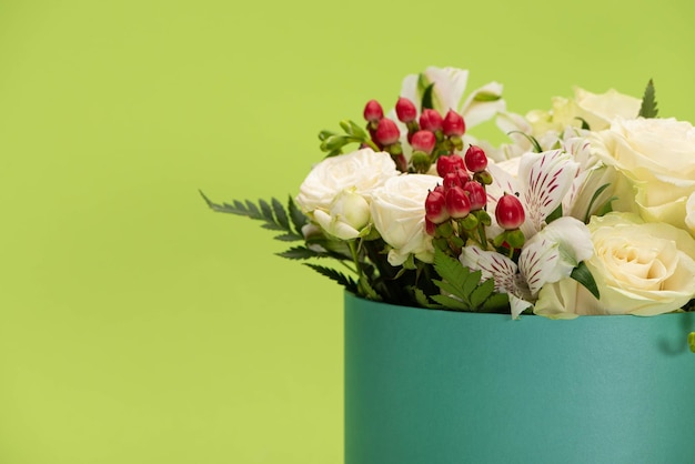 Ramo de flores frescas en caja de regalo aislado en verde