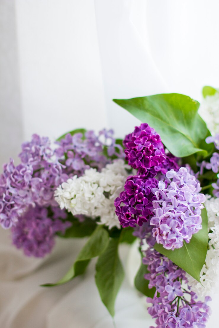 Ramo de flores frescas de color lilas en florero de vidrio de cerca