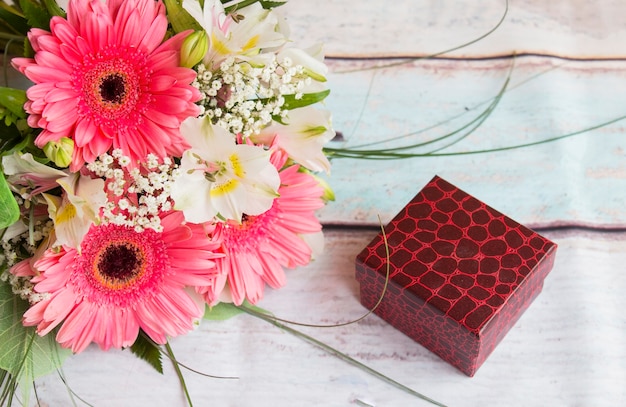 Foto ramo de flores de gerbera rosa y caja de regalo