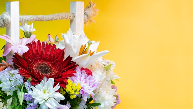 Un ramo de flores de gerberas, crisantemos, lirios. De cerca. Disparo macro. Fondo amarillo brillante.