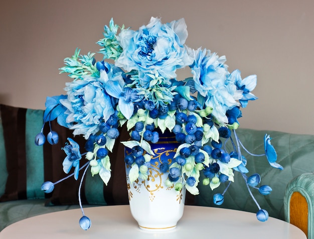 Ramo con flores grandes azules y cogollos cerrados. Flores artificiales en un jarrón para el interior.