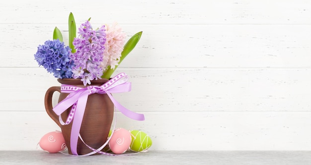 Ramo de flores de jacinto y huevos de Pascua en una mesa de madera plantilla de tarjeta de felicitación de Pascua con espacio para sus saludos