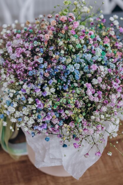 Un ramo de flores en un jarrón con una flor azul y violeta.