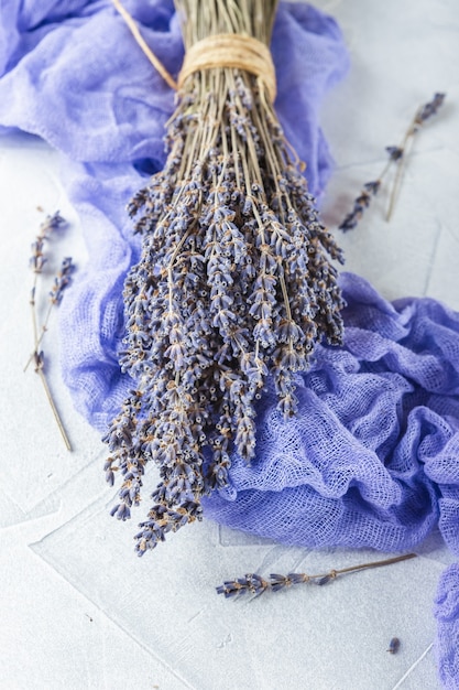 Ramo de flores de lavanda secas sobre superficie de hormigón blanco