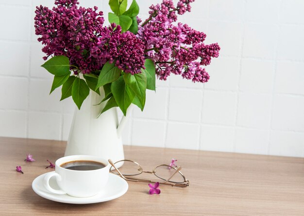 Ramo de flores lilas en un jarrón sobre una mesa de madera.