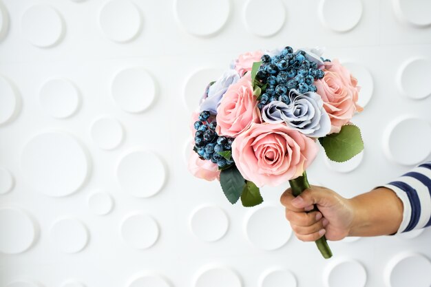 Ramo de flores en mano sobre fondo blanco