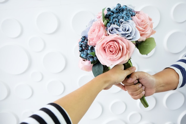 Foto ramo de flores en mano sobre fondo blanco