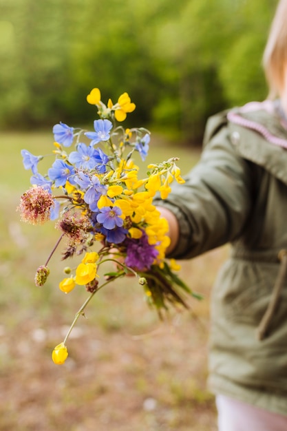 Ramo de flores en manos de una persona desenfocada