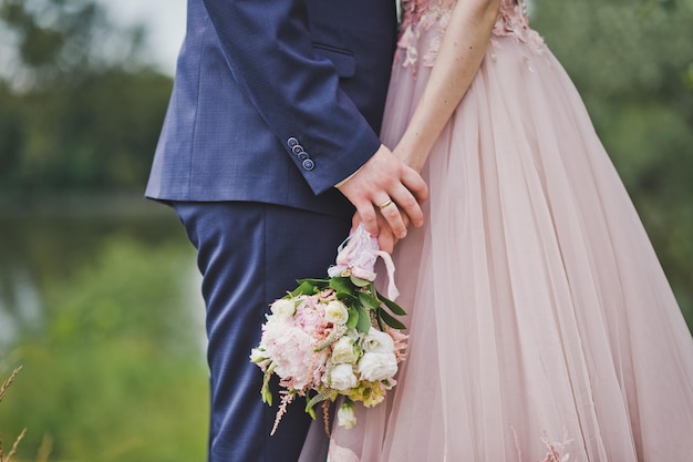 Un ramo de flores en manos de los recién casados en un paseo por natur